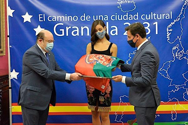 Luis Salvador y Sebastián Pérez entregan la bandera de Granada a la participante en el Miss World Spain.