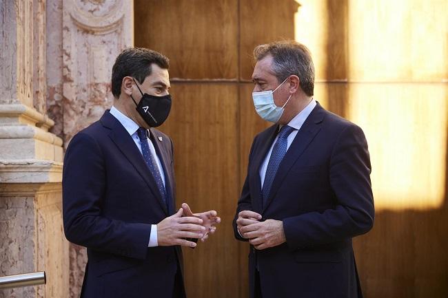 El presidente de la Junta, Juanma Moreno, (i) dialoga con el secretario general del PSOE-A, Juan Espadas, (d), el pasado 15 de diciembre de 2021, en el Parlamento.