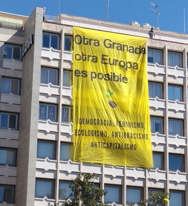 Activistas han desplegado una gran pancarta en la sede del BBVA al paso de la manifestación.