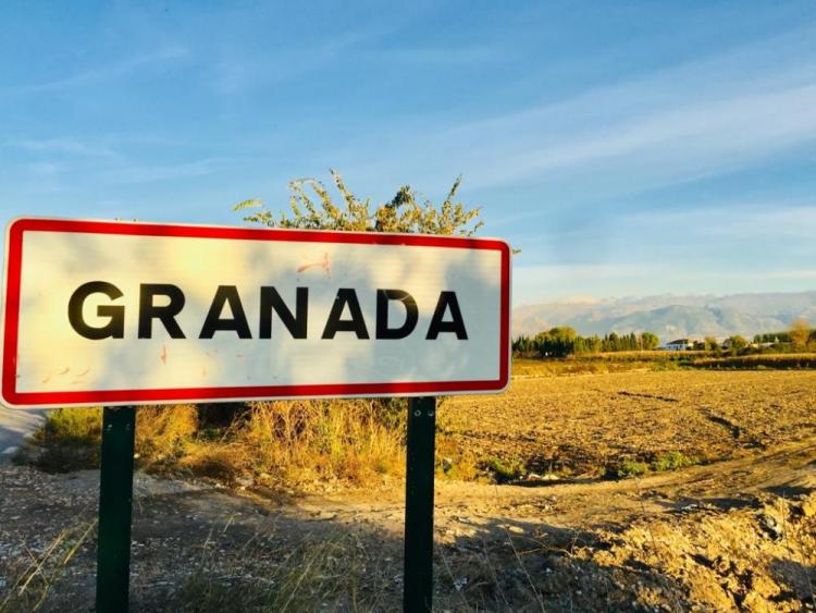 Cartel en uno de los accesos a Granada con la Vega y la Sierra al fondo.