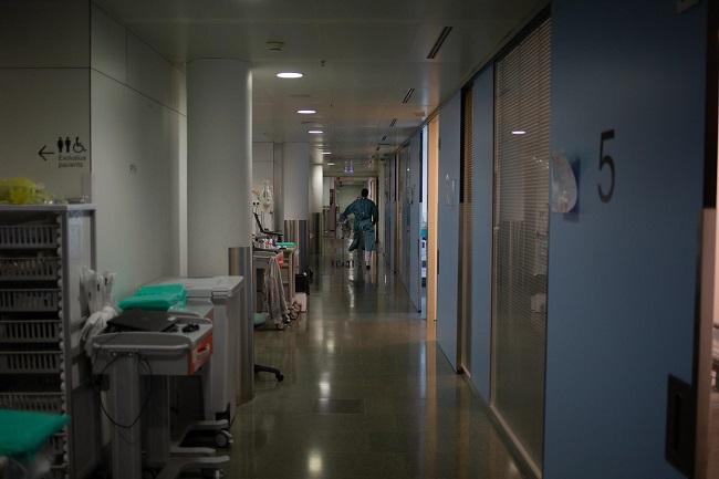 Un sanitario se mueve por un pasillo de una UCI de un hospital. 