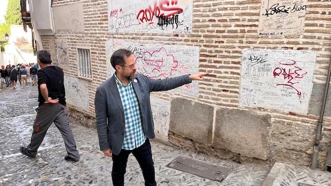 Juanjo Ibáñez, ante una fachada del Albaicín con numerosas pintadas.