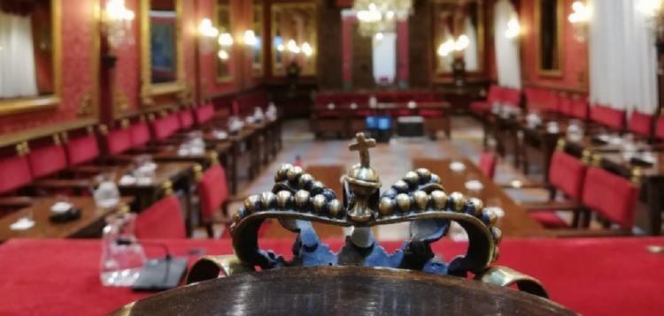 Salón de plenos vacío, con la silla de alcalde en primer plano.