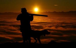 Un hombre cazando con su perro.