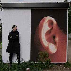 El alemán Efdemin, ante un mural promocional de su último disco.