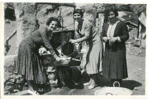 Mujeres trabajadoras sacan agua de un pozo. 
