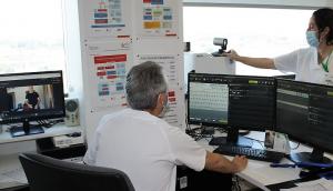 Un médico examina la información cardiaca de un paciente al que sigue en su casa por el monitor. 