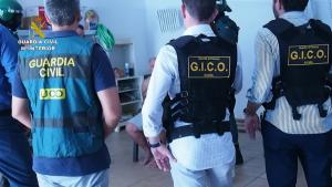 Los agentes, con uno de los detenidos.