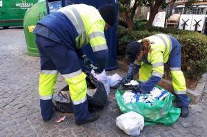 Empleados de Inagra abren bolsas de basura en la vía pública. 