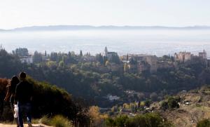 Vista de la Alhambra y detrás la ciudad con su 'boina' habitual'. 