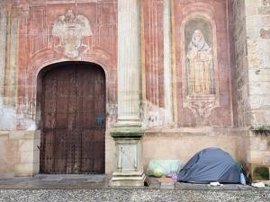 Una persona sin hogar en la puerta de la Iglesia de Santo Domingo. 
