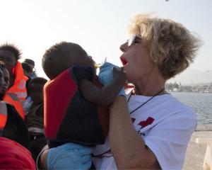 Una voluntaria de Cruz Roja, con uno de los bebés rescatados este lunes.