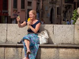 Una mujer se alivia del calor con un helado junto al Darro, en Plaza Nueva. 