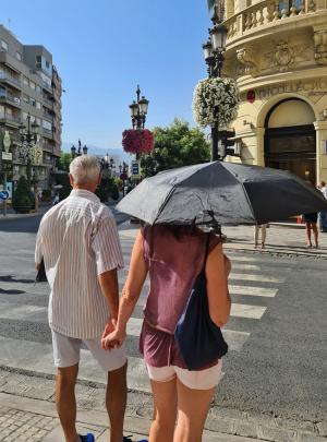 Dos turistas, de paseo bajo el sol, en el centro de Granada.