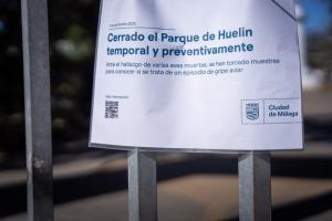Cartel informativo con el cierre de un parque en Málaga por sospecha de gripe aviar.