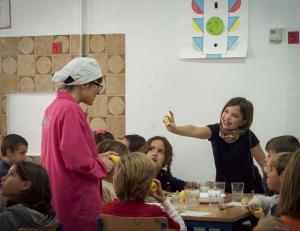 Una niña muestra al personal de cocina que se ha comido una manzana. 