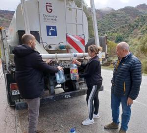 Habitantes de Ízbor llenan envases de agua del camión cisterna. 