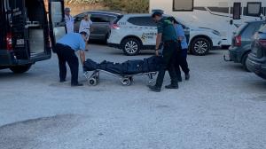 Los servicios funerarios, en presencia de la Guardia Civil, trasladan el cadáver.