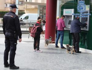 Un agente, junto a una sucursal bancaria. 