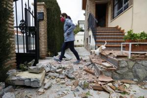 Una joven camina entre ladrillos caídos de una vivienda en Atarfe el pasado 23 de enero tras el terremoto de 4,4 grados.