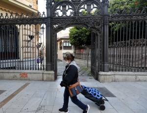 Una mujer camina por Gran Vía a la altura de la Capilla Real.