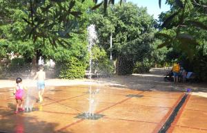 Menores refrescándose este viernes en las fuentes del paseo Emperador Carlos V, en el Zaidín.