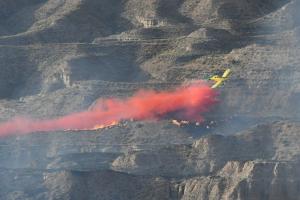 Uno de los aviones efectúa una descarga sobre el fuego.