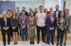 En el centro, los tres alumnos posan con sus medallas.