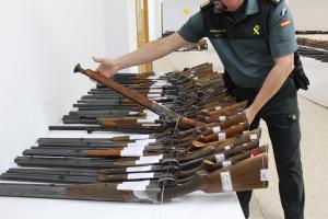 Un agente coloca las armas que se expondrán para la subasta.