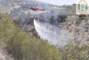 Un helicóptero descarga agua en el área incendiada. 