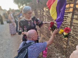 Hortensia y su hijo Francisco Ángel colocan flores en el Memorial ante el nombre de Francisco Torres Serrano.