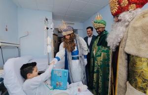 Los Reyes Magos saludan a uno de los niños hospitalizados. 