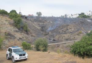 Un vehículo de la Guardia Civil, junto a la zona incendiada en Salobreña. 