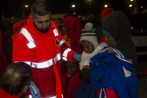 En la imagen, Cruz Roja atiende a las personas rescatadas a su llegada, de madrugada, al Puerto de Motril.