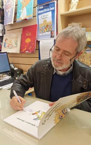  El ilustrador José Manuel Vigueras Roldán, firmando un ejemplar del libro La Alhambra de Boabdil.
