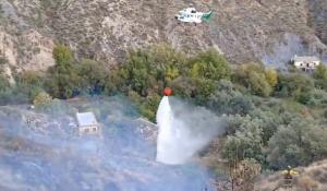 Un helicóptero descarga agua en el incendio de Laroles.
