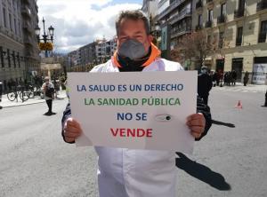 Uno de los participantes con un cartel en defensa de la sanidad pública