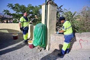 Los dos operarios de la brigada pintan un muro en el Mirador de San Miguel.