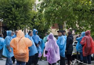 Turistas paseando bajo la lluvia este domingo.