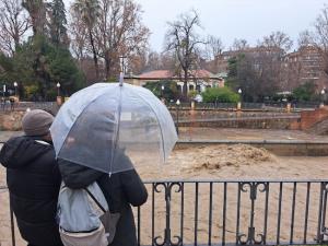 Una familia observa el caudal del Genil.