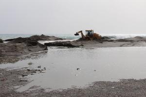 Máquina del Ayuntamiento trabajando en la salida de agua en la playa de Poniente.