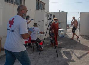 Voluntariado de Cruz Roja toma la temperatura y presta una primera asistencia a los migrantes.