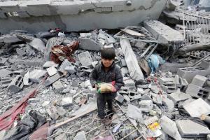 Un niño palestino con una bolsa de comida en una escuela bombardeada por el Ejército de Israel en la ciudad de Gaza.