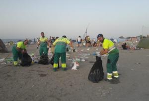 Operarios retiran basura en la playa.