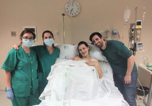 Una pareja con su bebé recién nacido y el personal sanitario.