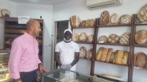 Ibrahima Gakoy, en su panadería, junto al alcalde de Otura, Nazario Montes. 