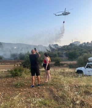 Vecinos de Dílar graban uno de los helicópteros que refrescaba la zona.