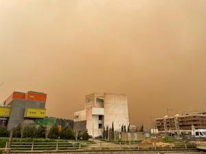 Imagen de la calima tomada en el PTS con un edificio manchado con el rastro que deja el barro y el cielo con el color de la arena. 