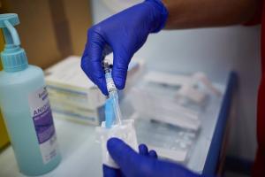 Un sanitario se prepara para administrar la vacuna de la gripe.
