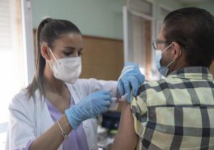 Una enfermera vacuna a un hombre contra la gripe y el Covid.